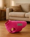 Load image into Gallery viewer, Pink fleece dog vest displayed on wooden floor with beige couch in blurred background.