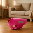 Load image into Gallery viewer, Pink fleece dog vest displayed on wooden floor with beige couch in blurred background.